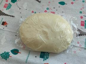 好的面团，它会挂在厨师机的钩子上，不会掉落的，我们用手撑开，可以看见面筋，但还没有连成一片，并没有形成大片的薄膜，所以我需要静止，让薄膜连起来，用保鲜膜把油皮包起来密封静置30分钟松弛。