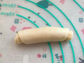 然后从下向上卷起，收口向下放，全部卷好，盖好保鲜膜，松弛15分钟。