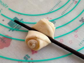 取出一个，收口朝上，在面卷中间用筷子压一下。