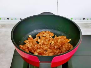 起油锅，倒入腌制好的鸡肉丁，煸炒至鸡肉变色。