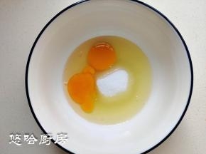 2个鸡蛋和细砂糖放在大碗中，鸡蛋打散搅匀即可，无需打发。