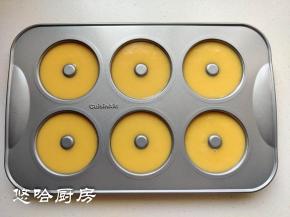 挤入甜甜圈模具中，九分满即可，在台面上稍微敲几下震出大气泡。配方中的材料正好挤满6连的模具。