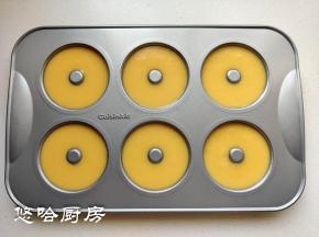 挤入甜甜圈模具中，九分满即可，在台面上稍微敲几下震出大气泡。配方中的材料正好挤满6连的模具。