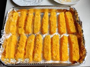 在炸蓝中铺一张锡纸，把沾满面包糠的牛奶条摆放在炸蓝中，牛奶条之间隔一点距离。