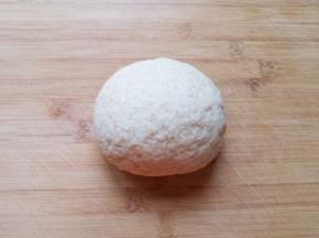 将搅拌好的絮状小麦粉倒在案板上，揉成面团，放入盆里盖上保鲜膜醒半个小时。