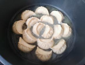 加入没过锅贴三分之一的水，盖上锅盖焖煮至水收干。