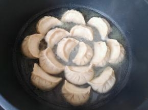 加入没过锅贴三分之一的水，盖上锅盖焖煮至水收干。