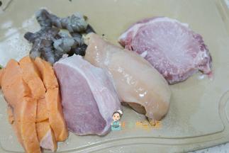 把所有的肉全部洗干净，虾跟鱼可以用姜片或者柠檬腌渍十五分钟去腥。冷水加入几片姜片放入三文鱼跟虾仁煮熟捞出