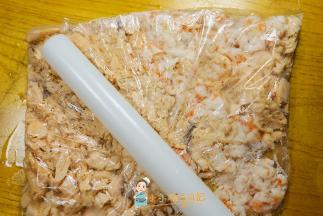 把虾仁跟三文鱼装入一次性袋里用擀面杖敲散，这样就可以了