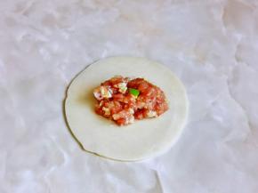 取一张饺子皮，放上适当的馅料，根据个人喜欢包起来即可。