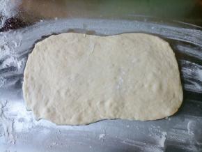 案板撒一层薄粉，将面团取出，轻轻擀成长方形面片，不要排气！不要大力！