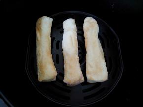 到时间后，取出炸篮，将油条翻一个面，表面再刷一层薄油，再次烤5分钟。