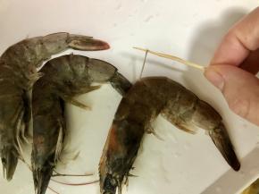 把虾用清水清洗干净，尤其是虾的虾头和虾的腹部。然后用竹签插入虾背的第二节，轻轻松松的就能把虾线完整的挑出，并且剪掉虾须。