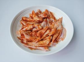 带上手套用手把调味料与鸡翅尖抓拌均匀，腌制1小时左右。
