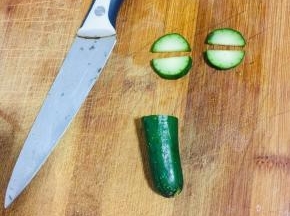 黄瓜取它的根部，对半切开，再切出4个小半圆备用！