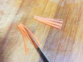 胡萝卜切成片，再切成丝，记住顶端不要切断了！