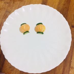 把小金桔也对半分开，摆在盘子里，黄瓜片摆在桔子的两头！（如图）