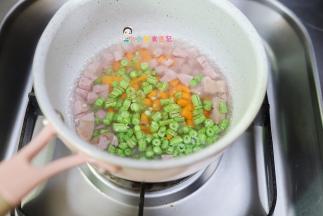 锅里放入水把香肠、胡萝卜、豇豆放在水里煮熟，因为香肠是有味道的切碎水煮后味道可以去掉很多，因为一岁以上我们给孩子吃也是尽量少加调味品，所以我三岁以内基本上都不调味