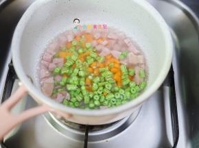 锅里放入水把香肠、胡萝卜、豇豆放在水里煮熟，因为香肠是有味道的切碎水煮后味道可以去掉很多，因为一岁以上我们给孩子吃也是尽量少加调味品，所以我三岁以内基本上都不调味