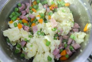 然后加入豇豆、香肠、胡萝卜、奶酪碎混合均匀，做成一个个圆饼