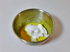 取三分之一的蛋白霜加入蛋黄糊器具中，用硅胶铲翻拌均匀。