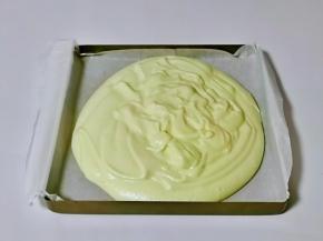 把拌好的蛋糕糊倒入垫好油纸的烤盘中，轻轻震几下，将气泡震出。