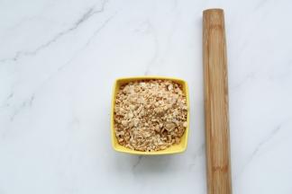 熟花生仁放入保鲜袋中，用擀面杖擀碎备用。