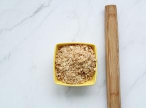 熟花生仁放入保鲜袋中，用擀面杖擀碎备用。