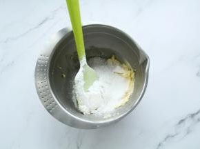 软化到用刮刀可以轻易抹开的黄油，将纯糖粉筛入（可以用普通糖粉，纯糖粉容易结块，所以需要过筛），用刮刀稍微混合，看不见糖粉即可，防止打发时候糖粉飞溅。