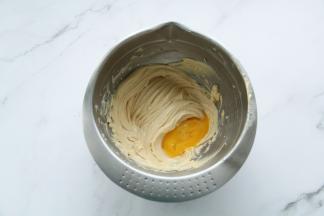 稍微打混合即可，然后常温全蛋液分2-3次加入，打到蛋黄和黄油糊完全混合均匀再加下一次，直到蛋液全部加完。一定要常温蛋液，防止温差大使黄油油水分离。