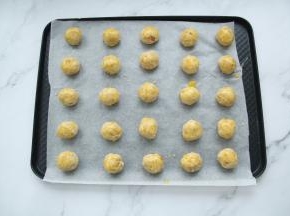 戴上PVC手套，取面团15克一个，搓圆，摆放在垫了油纸的烤盘上，间隔开，烤完会膨胀！然后刷上一层蛋黄液，厚一些没关系，蛋黄液自然滴落。