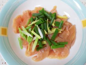 将切好的肉片放入盘子里，加入小葱段和生姜丝。