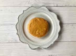 取一个盘子，把一半的红薯泥盛入盘中，借助勺子或抹刀把红薯泥整成圆饼形