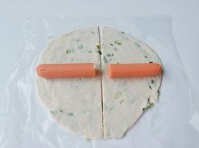 一根火腿肠对半切开，放到手抓饼上面。