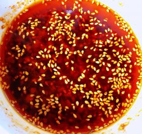 锅中烧开热油趁热分三次浇在蒜粒辣椒面上面不停的均匀搅拌瞬间满屋飘香