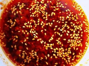 锅中烧开热油趁热分三次浇在蒜粒辣椒面上面不停的均匀搅拌瞬间满屋飘香