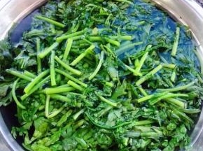 锅中烧开水放入茼蒿烫一下立刻捞出放入冷水中过凉沥干水份