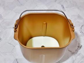 首先将牛奶加入面包机桶中。