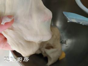 用厨师机搅打至面团细腻能拉出较厚的膜，放入软化的黄油，继续搅打。