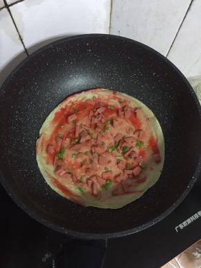 撒上适量的火腿肠丁和葱花！