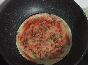 撒上适量的火腿肠丁和葱花！