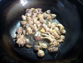 锅烧热，倒入小半碗油，下鸡肉炸一下，煎至表面微焦，这样鸡肉才香。中间加入几片姜一起煎一下。