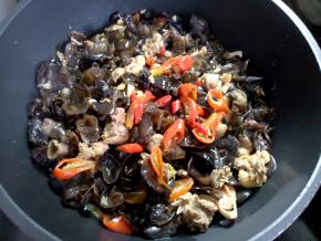 鸡肉煮得差不多了，可以尝一块熟没，不熟再煮会，熟了就加辣椒加木耳，加点生抽调下味，拌匀，开盖再煮两三分钟，收一下多余的汤汁，还剩少许汤时就可以了。最后起锅装盘。