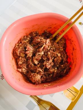 肉馅中倒入适量的老抽上底色，再倒入适量的生抽提鲜，倒入一勺五香粉，适量的胡椒粉，一勺蚝油，把它搅拌均匀！