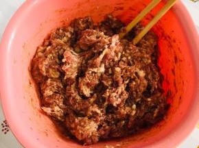 肉馅中倒入适量的老抽上底色，再倒入适量的生抽提鲜，倒入一勺五香粉，适量的胡椒粉，一勺蚝油，把它搅拌均匀！
