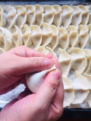 两只手拿住饺子，捏紧，大拇指的地方同时向中间挤压一下！