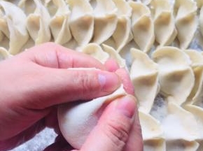 两只手拿住饺子，捏紧，大拇指的地方同时向中间挤压一下！