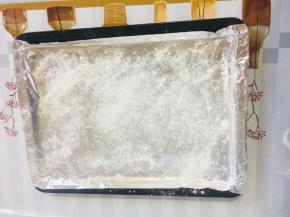 烤盘上铺上锡纸，撒少许的面粉，以免饺子底部粘连！