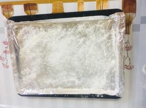 烤盘上铺上锡纸，撒少许的面粉，以免饺子底部粘连！