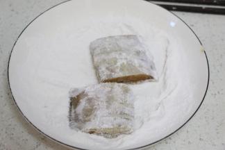 腌好的带鱼裹一层玉米淀粉。